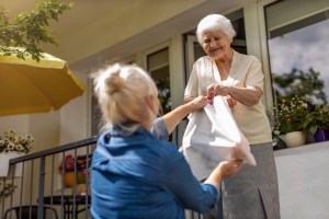 A volunteer delivers materials to a homebound library patron