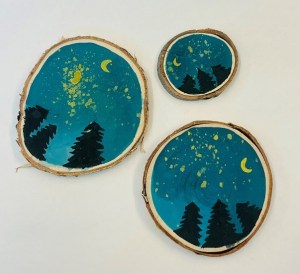 Painting of treetops against a night sky on wood