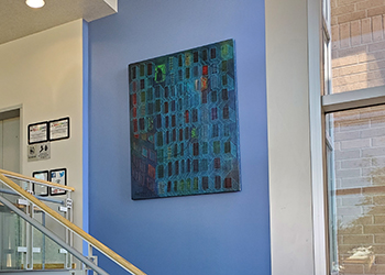 Stairwell with a blue background wall featuring a contemporary painting of repeating blue rectangles reminiscent of a city map.