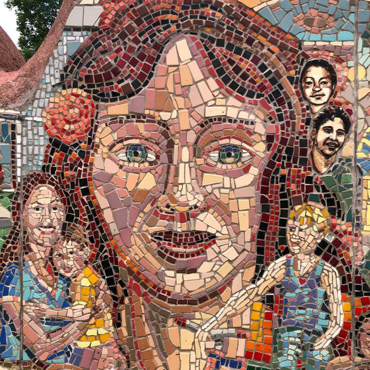 close up of Unity Project mosaic mural showcasing a woman's face with a rose in her hair surrounded by several children.