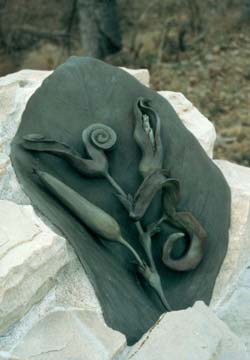 an up close image of a bronze flower on a rock