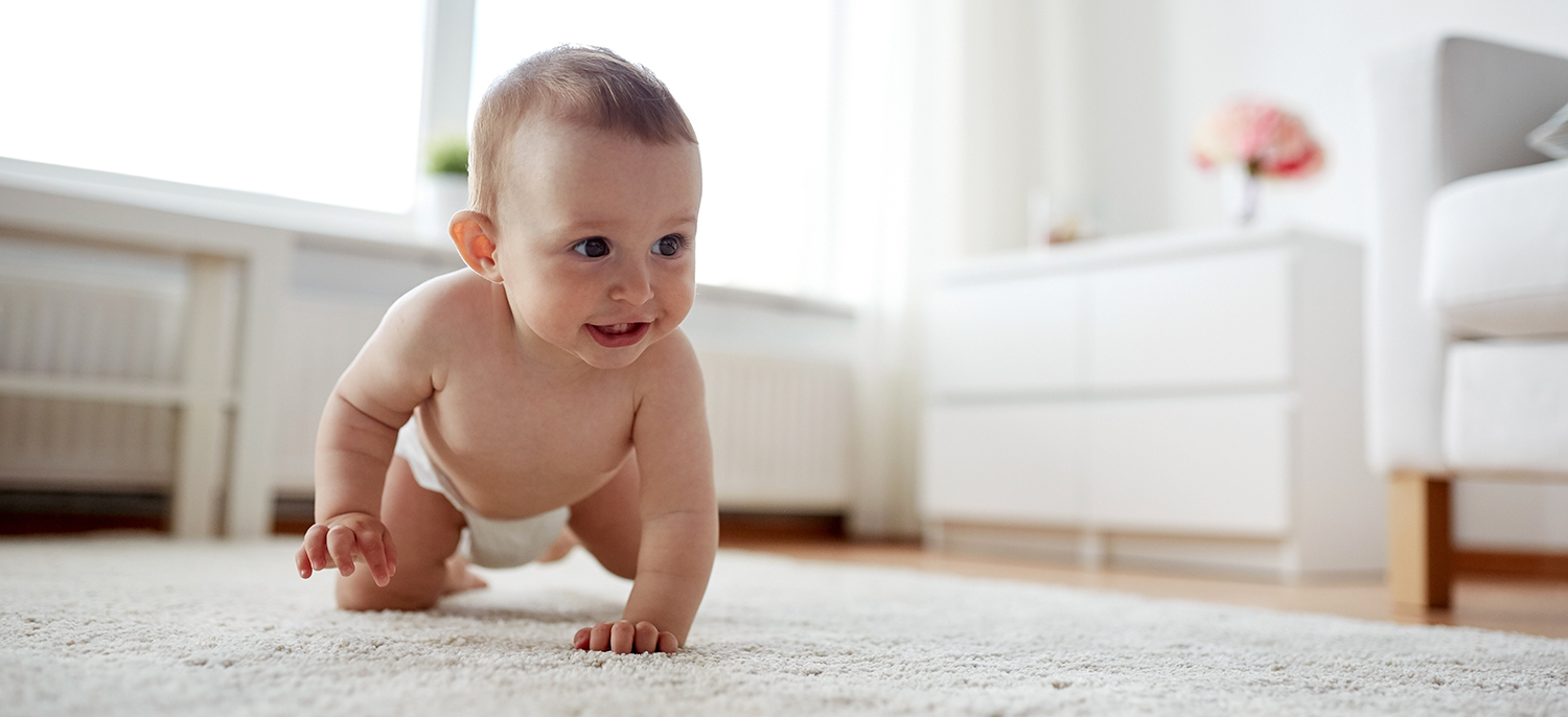 little baby in diaper crawling on floor at home