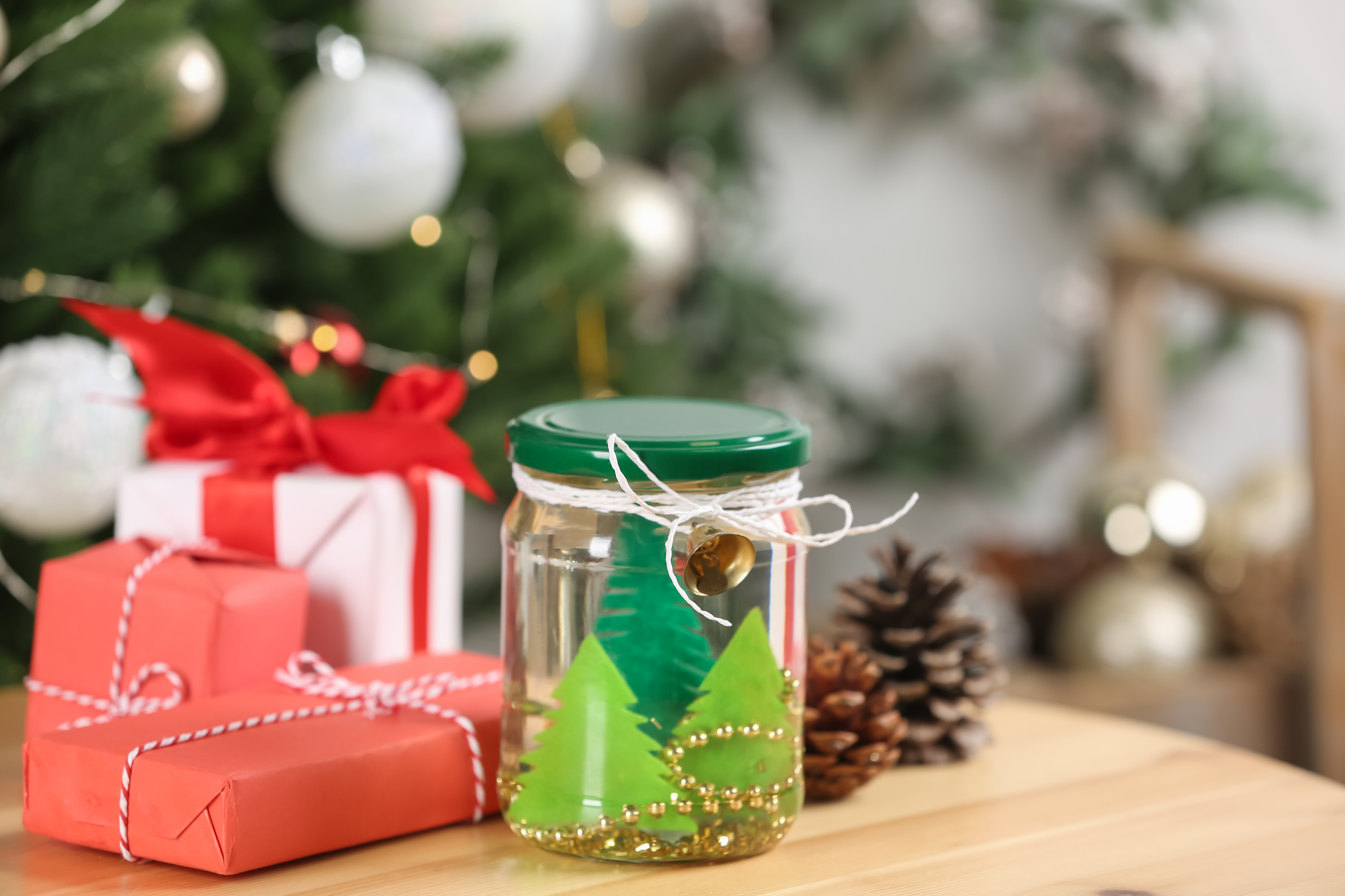 Handmade snow globe and Christmas decorations on wooden table