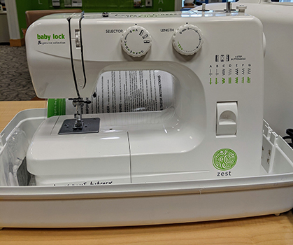 White sewing machine in a plastic carrier