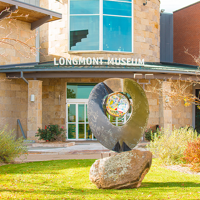 A sculpture is shown in front of the Longmont Museum entrance