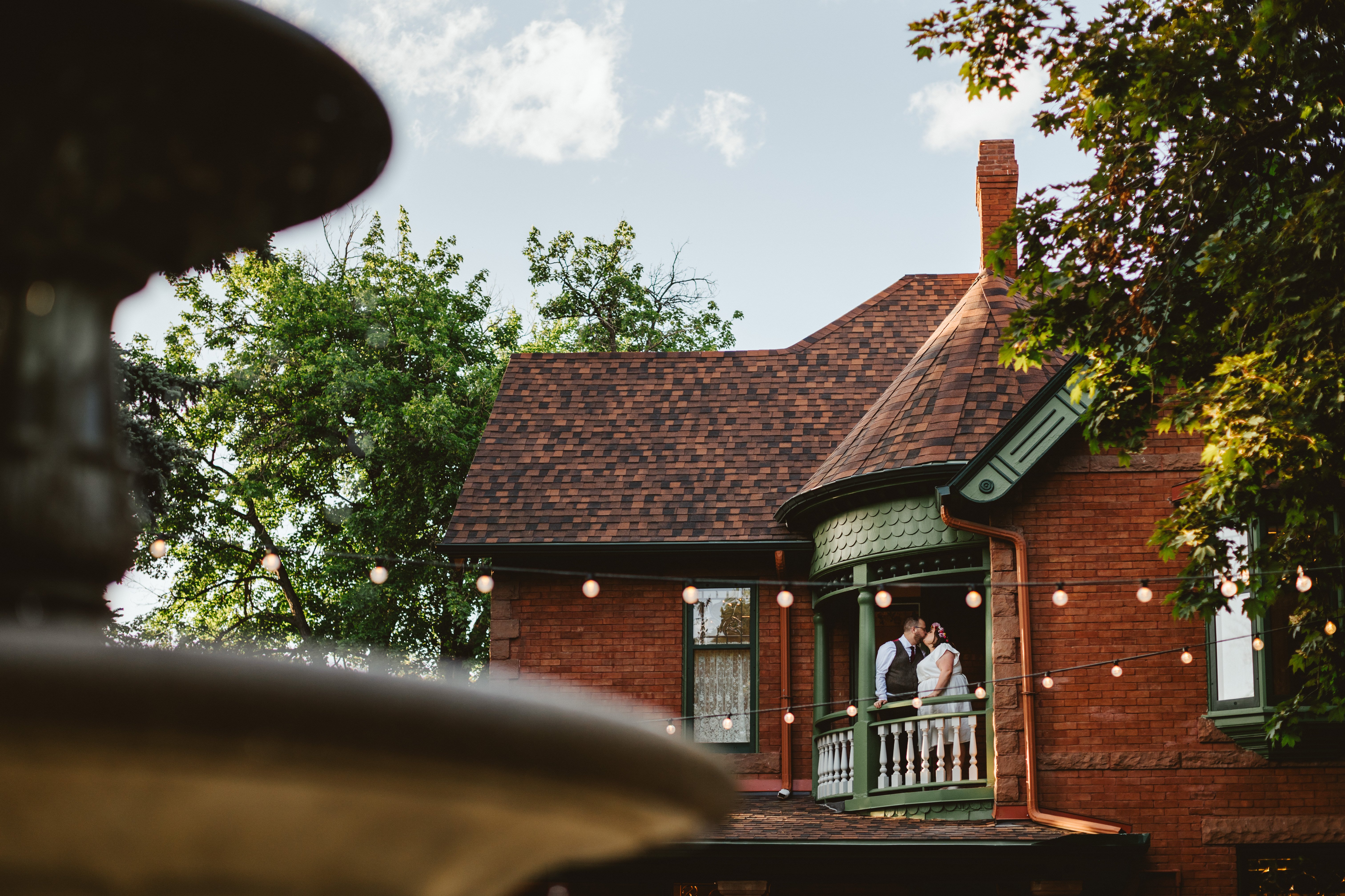 Bride and groom standing on the balcony of the Callahan House in an embrace.