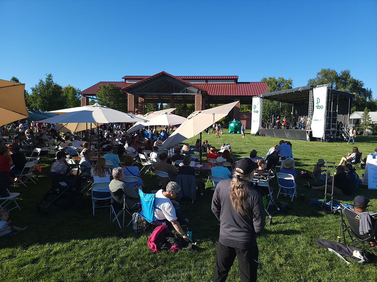 View of people listening outdoors to a band on a stage at Rhythm at Roosevelt.