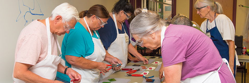 Several seniors work on a craft project.