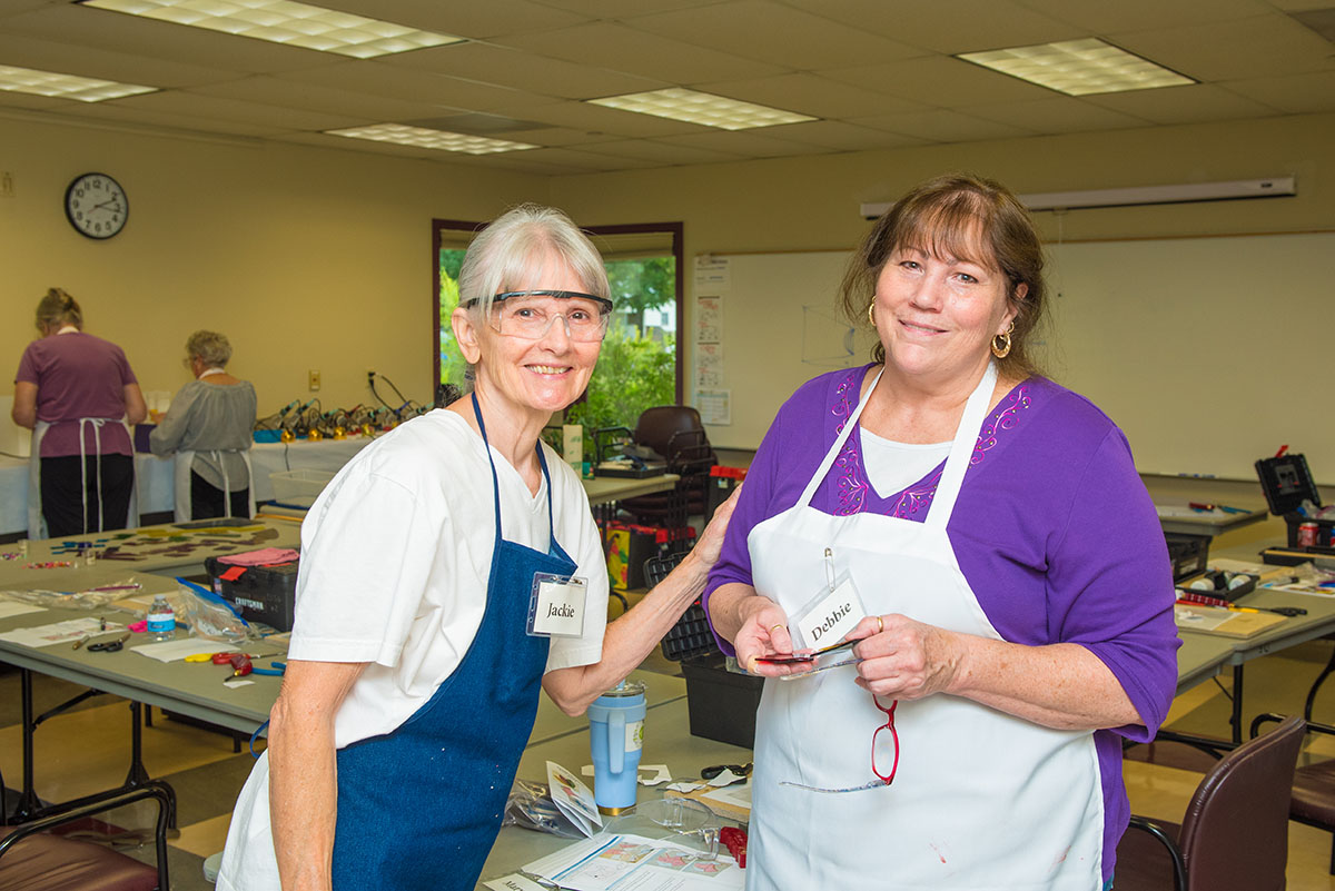 Two Senior Center staff members smile