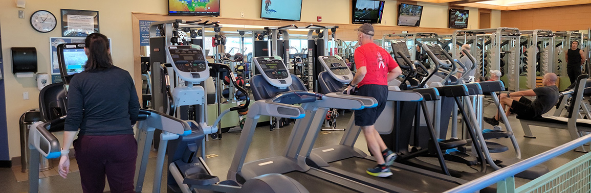 Individuals using the treadmill and other cardio equipment in the Longmont Recreation Center fitness area.