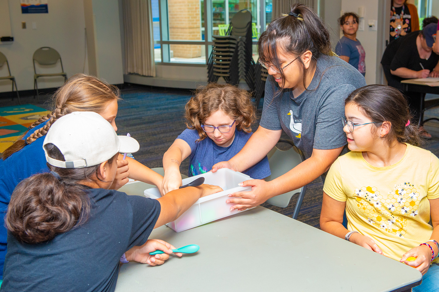 A group of elementary aged kids grab supplies during a Library program