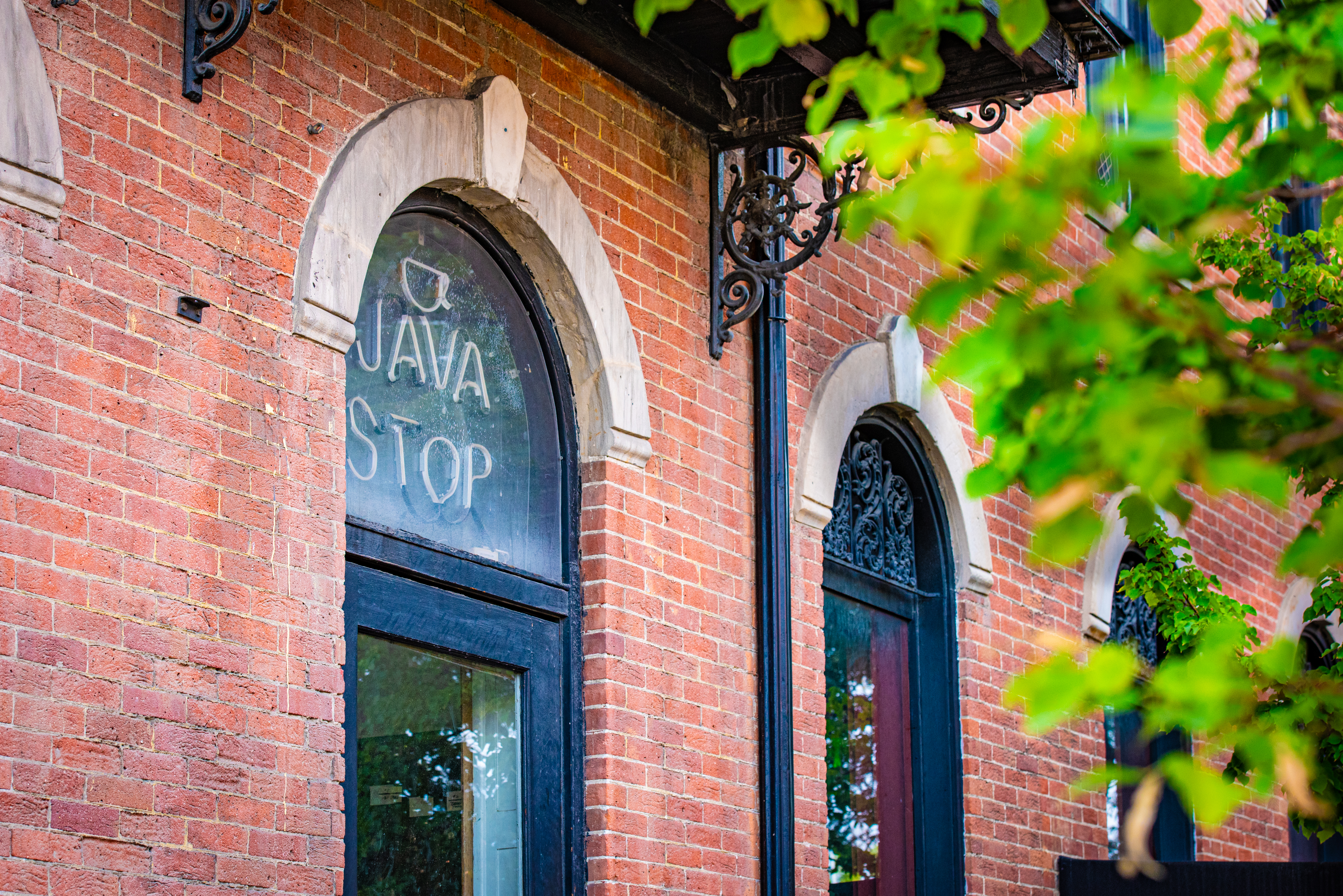 Brick building with arched windows, A Neon sign reads "the Java Stop"