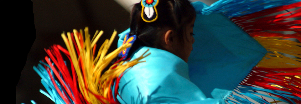 A Native American dancer, wearing traditional garments, is seen in a close-up image.